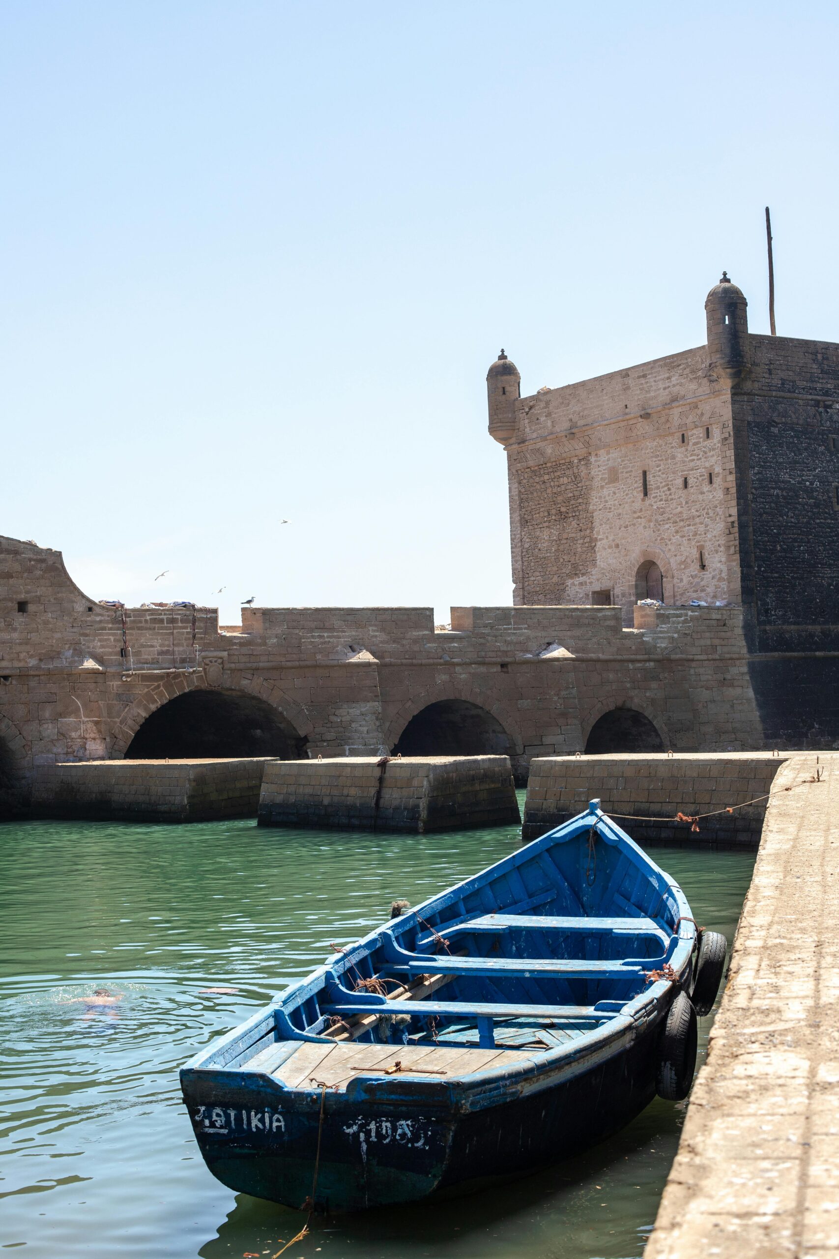 pexels-photo-10727335-10727335 A traditional blue boat rests in the historic Essaouira harbor, Morocco's coastal gem.