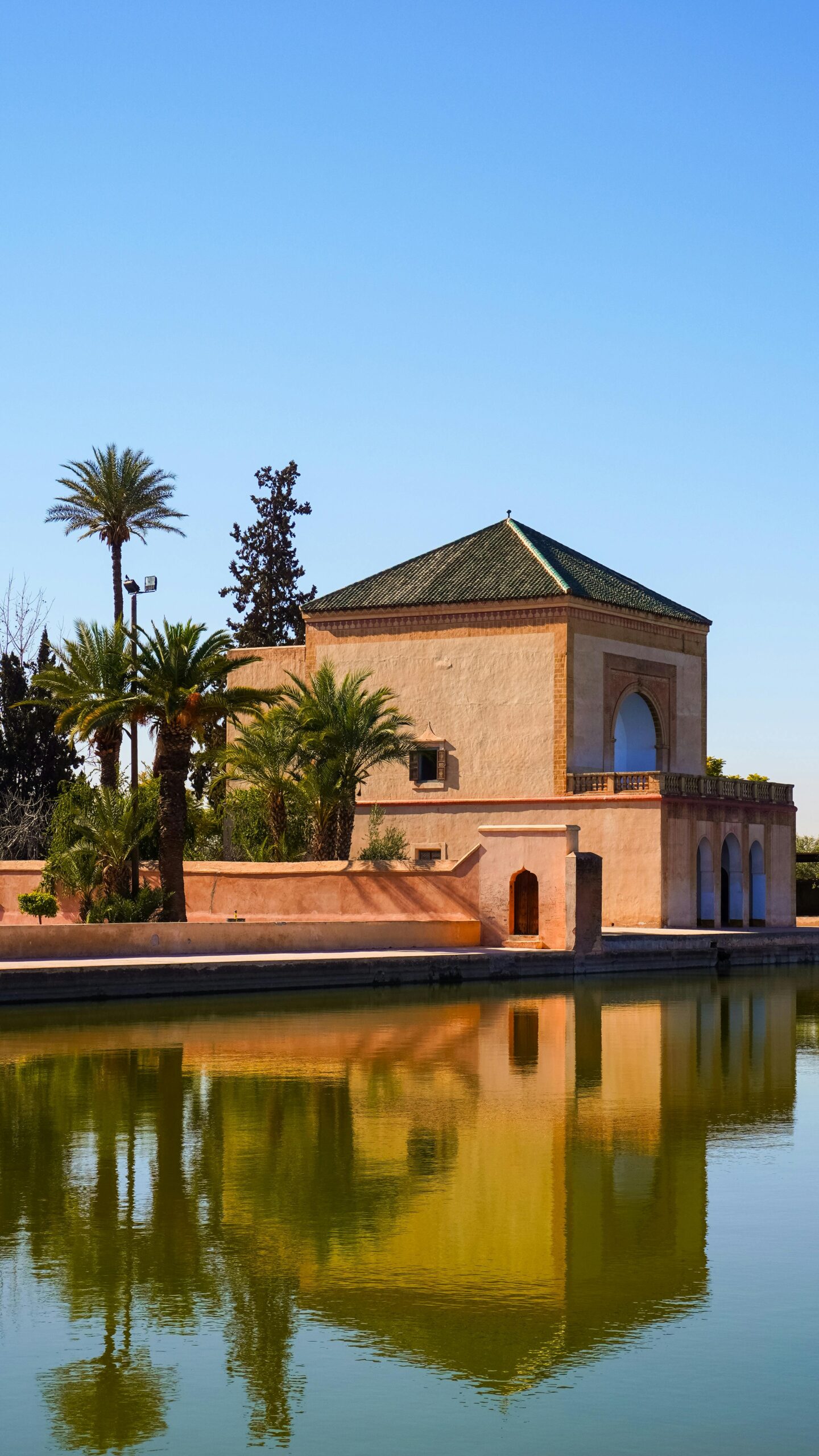 pexels-photo-31004504-31004504 Beautiful reflection of the Menara Gardens pavilion in Marrakech on a sunny day with clear blue skies.