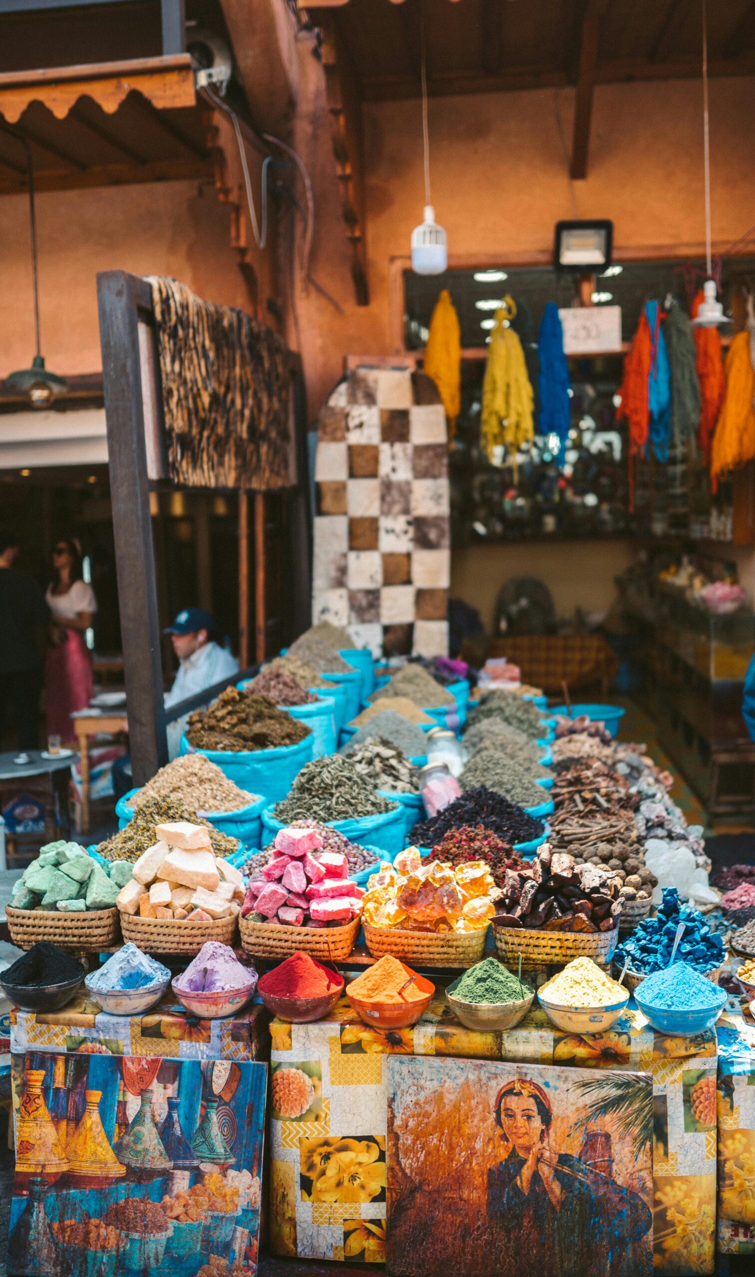 pexels-photo-4502964-4502964 Colorful spices and fabrics displayed at an outdoor market in Marrakesh, Morocco.