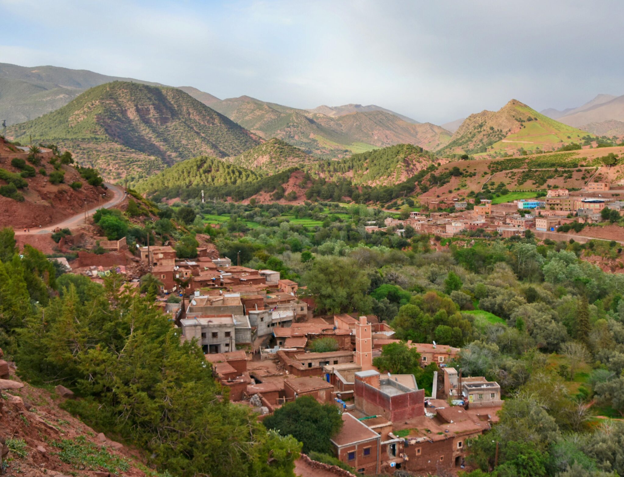 pexels-photo-6807646-6807646 Scenic aerial view of Ait Barka village amidst lush green valleys and rugged mountains.
